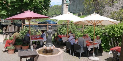 Essen-gehen - Italien - Idyllischer Gastgarten zwischen Kirche und Schloß mit Blick auf die Zillertaler Alpen - Restaurant Turmwirt