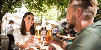 Essen-gehen - Preisniveau: €€ - Salzburg - Die schattenspendenden Kastanienbäume im Biergarten laden zum Verweilen ein. - Bräustüberl in der Stiegl-Brauwelt