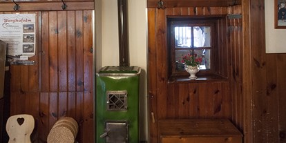 Essen-gehen - Niederösterreich - Der wohlig warme Holzofen für kalte Wintertage verbreitet Wohlbehagen und ladet zum Verweilen ein. - Gasthaus Buchegger
