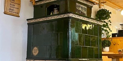 Essen-gehen - Feldberg - Gemütlicher Kachelofen im Gastraum vom Strauß - Gasthaus zum Strauß