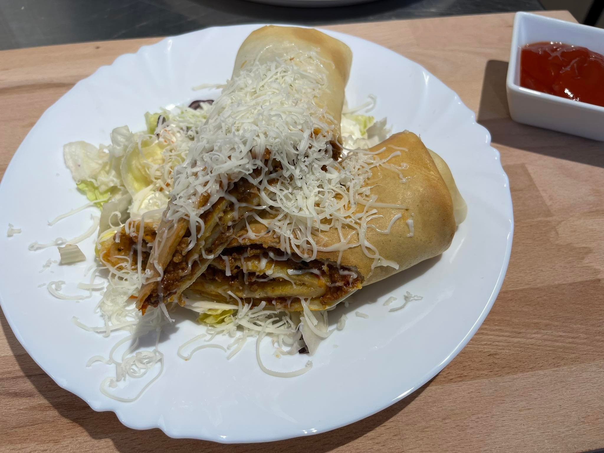 Restaurant: Bologna- Riese Pfannkuchen gefüllt mit Schweinefleisch und italienischer gewürzter Tomatenragout 
mit geriebener Käse mit Frischer Salat und Knoblauchmayonnaise  - Boheme Bistro und Ungarischer Shop