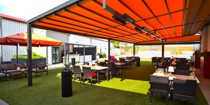 Essen-gehen - Ambiente: klassisch - Außenterrasse mit Pergola, Outdoorküche und Kräutergarten mit Blick auf den Beachvolleyballplatz. - Restaurant Maracana