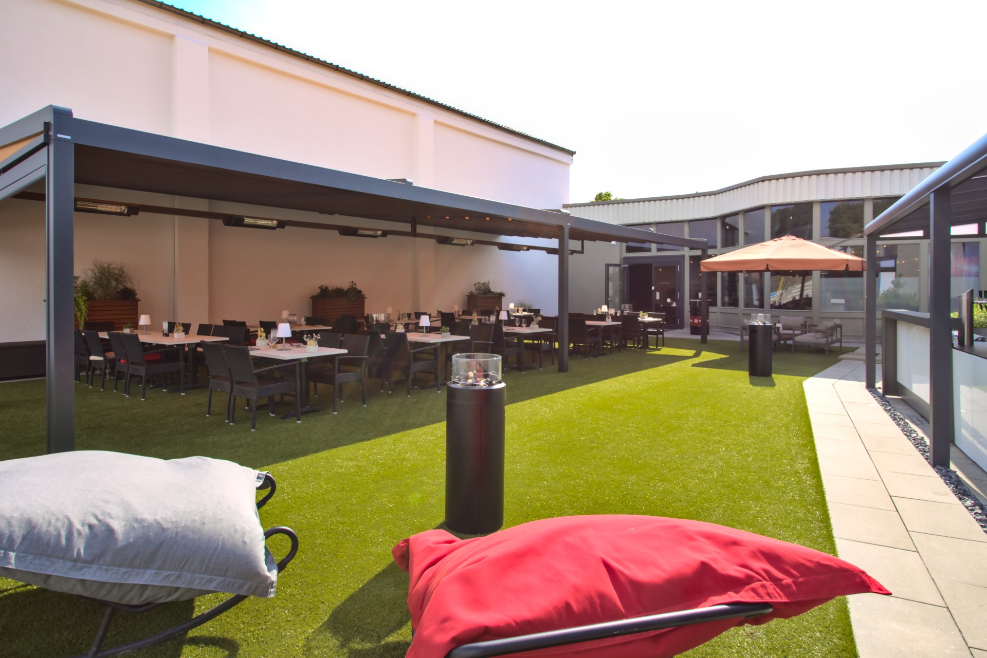 Restaurant: Außenterrasse mit Pergola, Outdoorküche und Kräutergarten mit Blick auf den Beachvolleyballplatz. - Restaurant Maracana