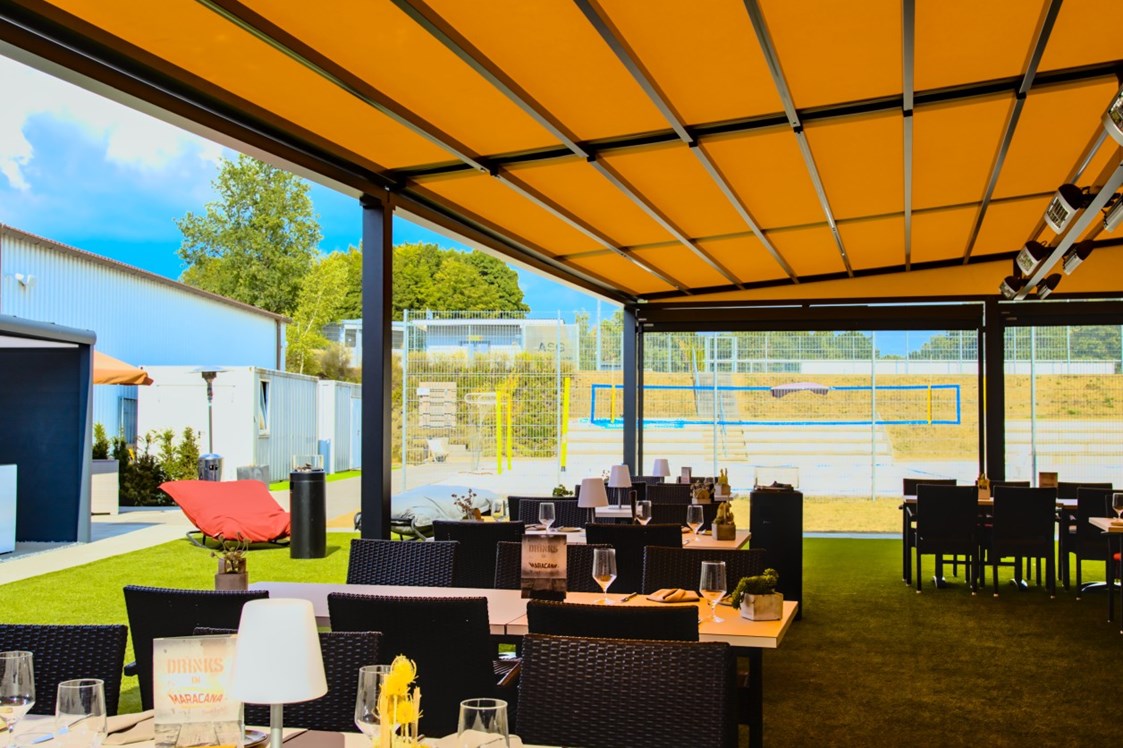 Restaurant: Außenterrasse mit Pergola, Outdoorküche und Kräutergarten mit Blick auf den Beachvolleyballplatz. - Restaurant Maracana