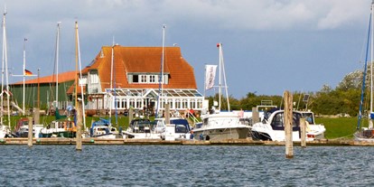 Essen-gehen - rollstuhlgerecht - Baltrum - Das Restaurant "Kajüte am Hafen" Langeoog vom Wasser aus gesehen. - Kajüte am Hafen Langeoog