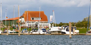 Essen-gehen - Niedersachsen - Das Restaurant "Kajüte am Hafen" Langeoog vom Wasser aus gesehen. - Kajüte am Hafen Langeoog