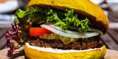Essen-gehen - Ambiente: klassisch - Veganer Black Bean Burger: Burger im Curcuma Bun mit einem Patty aus Bohnen, Soja und Linsen, abgerundet mit Cashewnüssen hausgmachter Sojamayo und Gurkenrelish - Murrerwirt in Aiterhofen